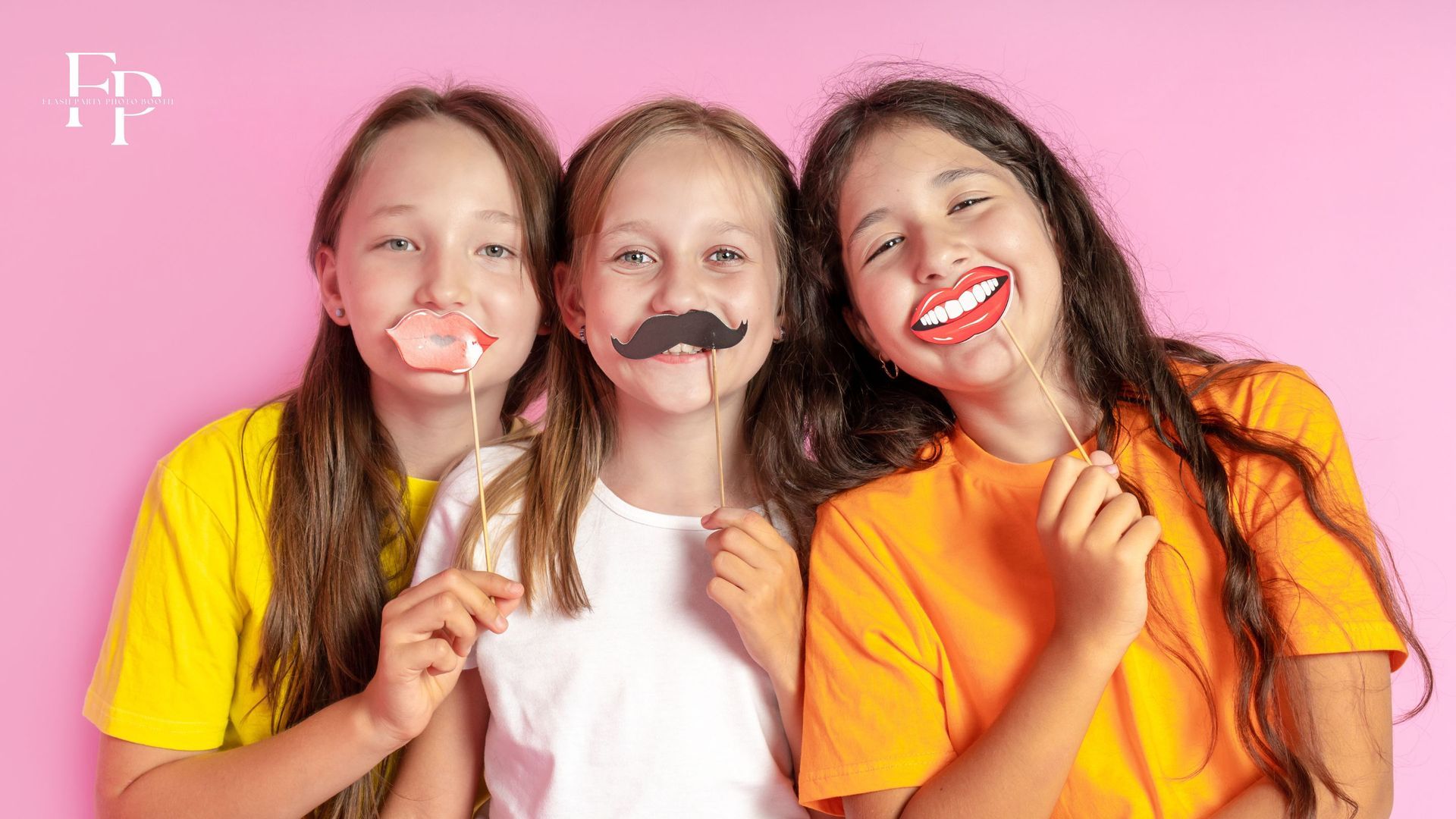 Three girls with props pose at a photo booth rental