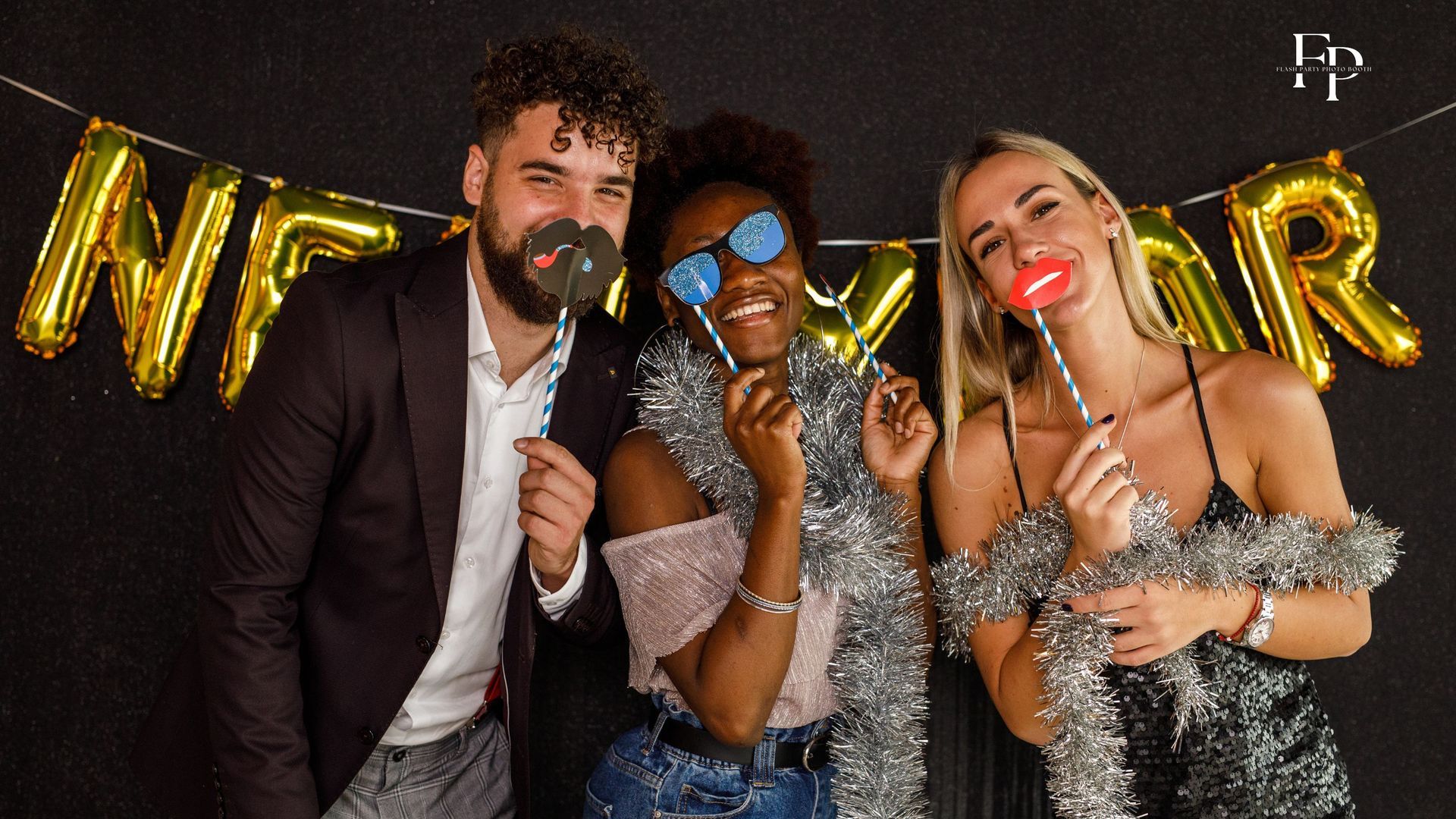 Three friends having fun at a photo booth rental in Midland