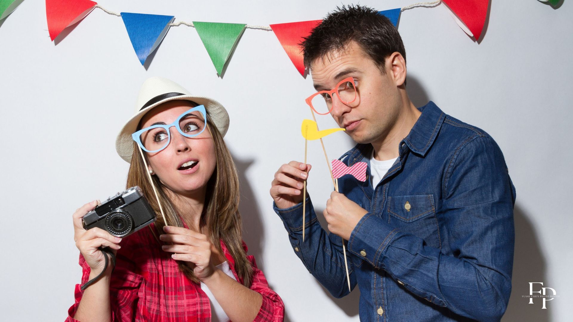 Two guests enjoying and posing at a photo booth rental at a birthday party in Mansfield