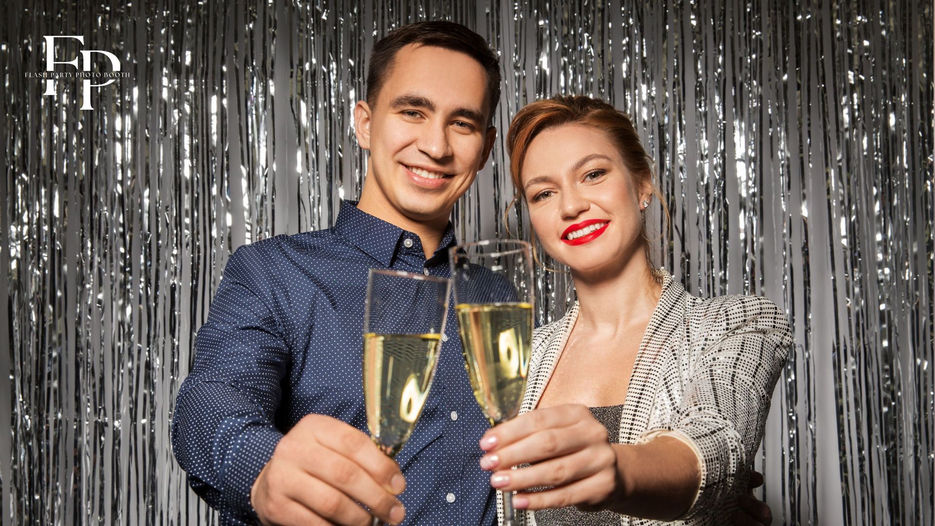 Two guests enjoying and holding drinks while posing at a photo booth rental in Houston