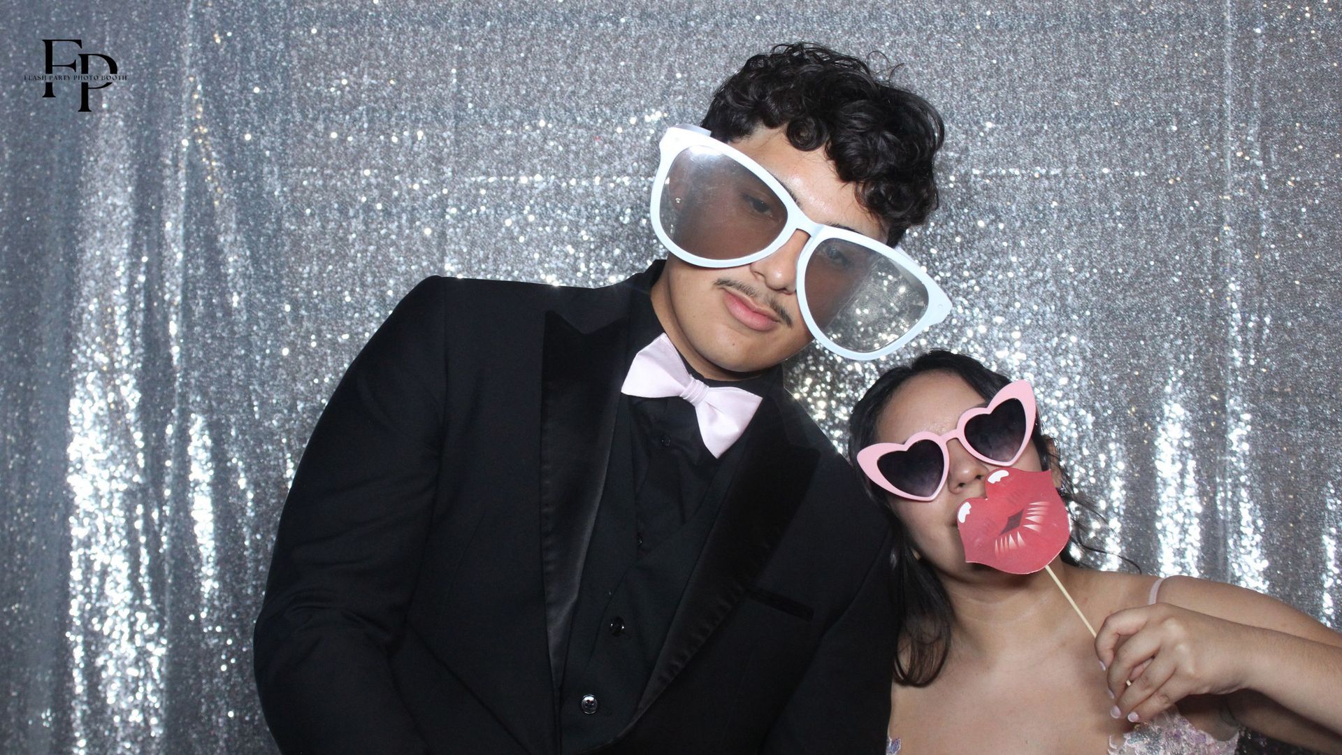 A man and a woman with shades having fun in a Mirror Photo Booth.