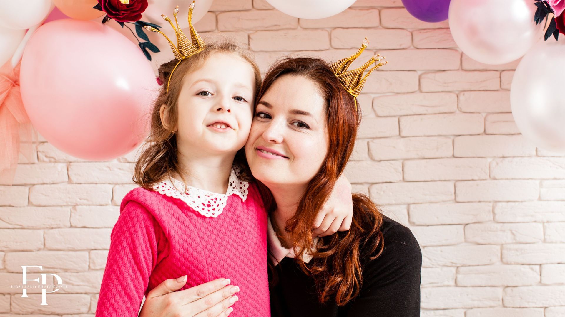 A mom and daughter posing behind a pink-themed birthday party set up in Houston
