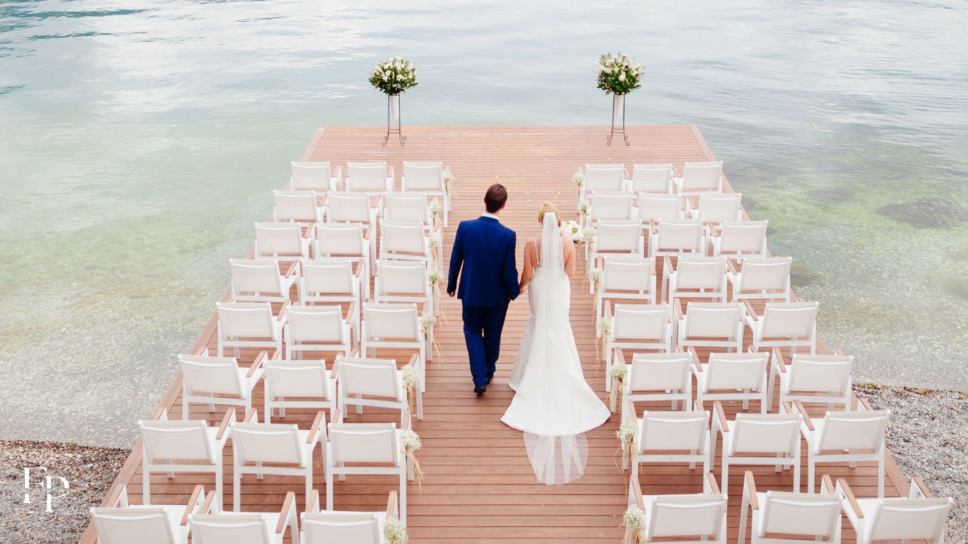 The bride and groom walk towards their wedding venue in Manor, at a beach where the ceremony will take place