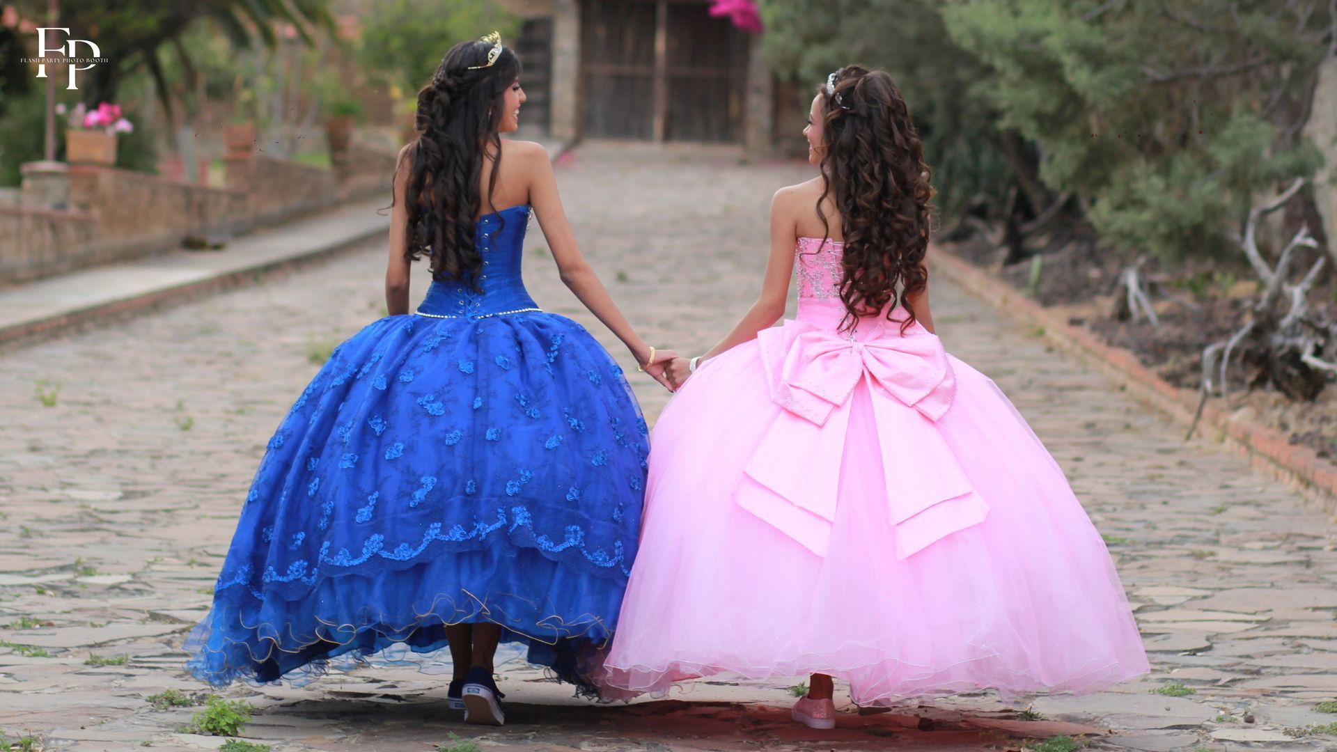 The quinceanera celebrant and her best friend in stunning gowns walking towards the quinceanera venue in Manor