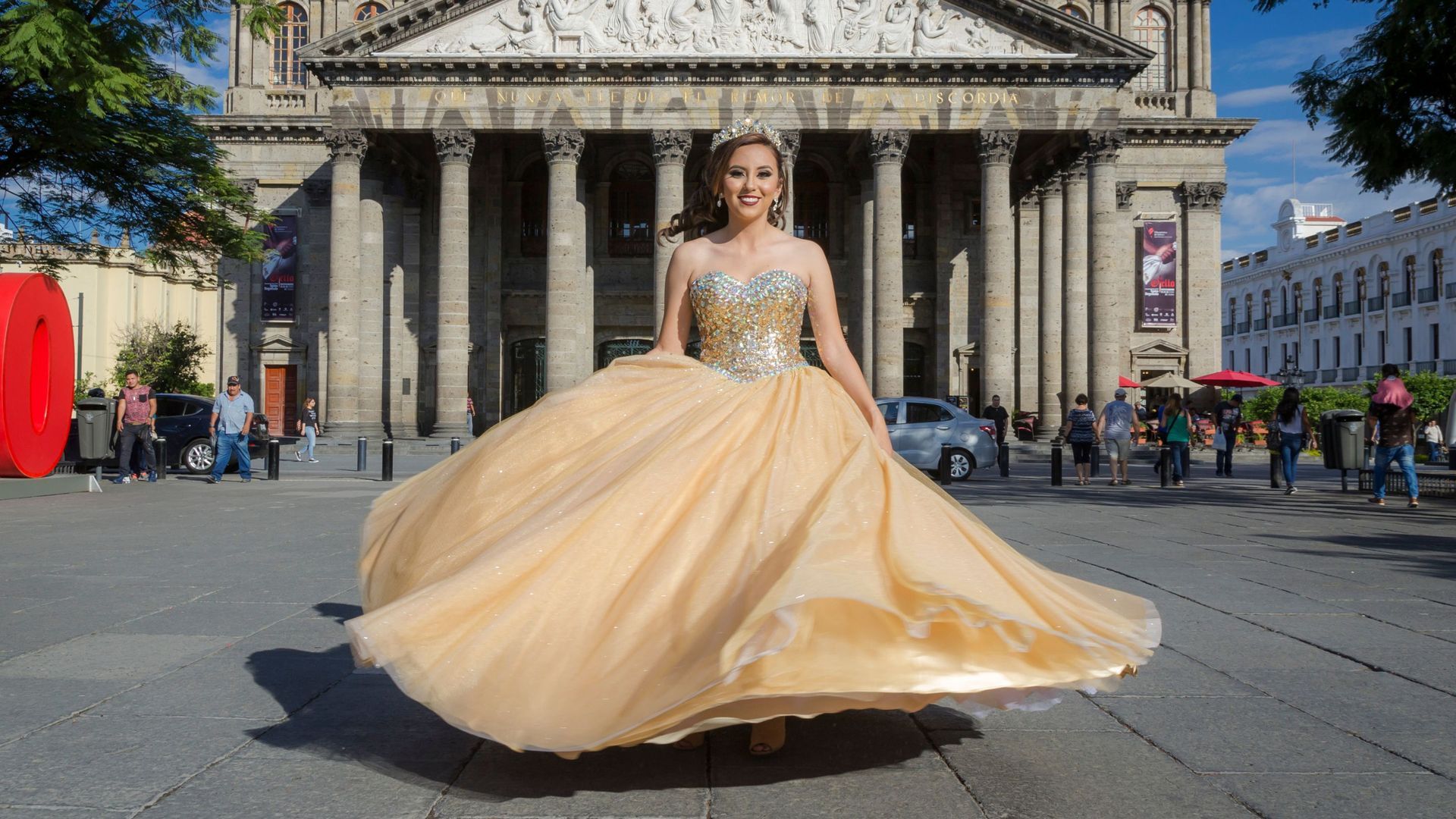 A celebrant in a stunning gold gown striking a pose for a photo shoot for her quinceanera