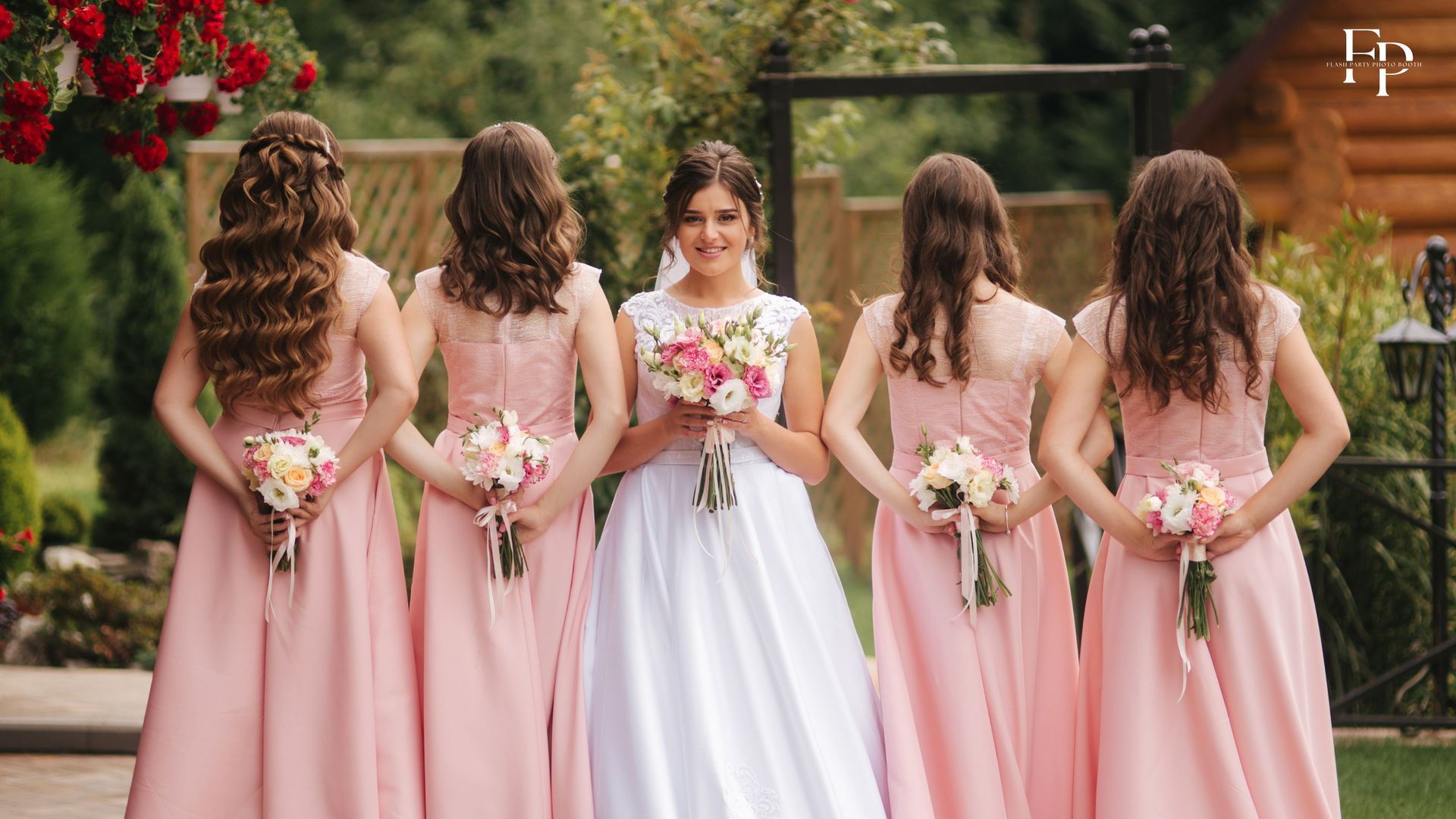 The bride with the bridesmaids holding bouquets at their wedding ceremony in Mansfield