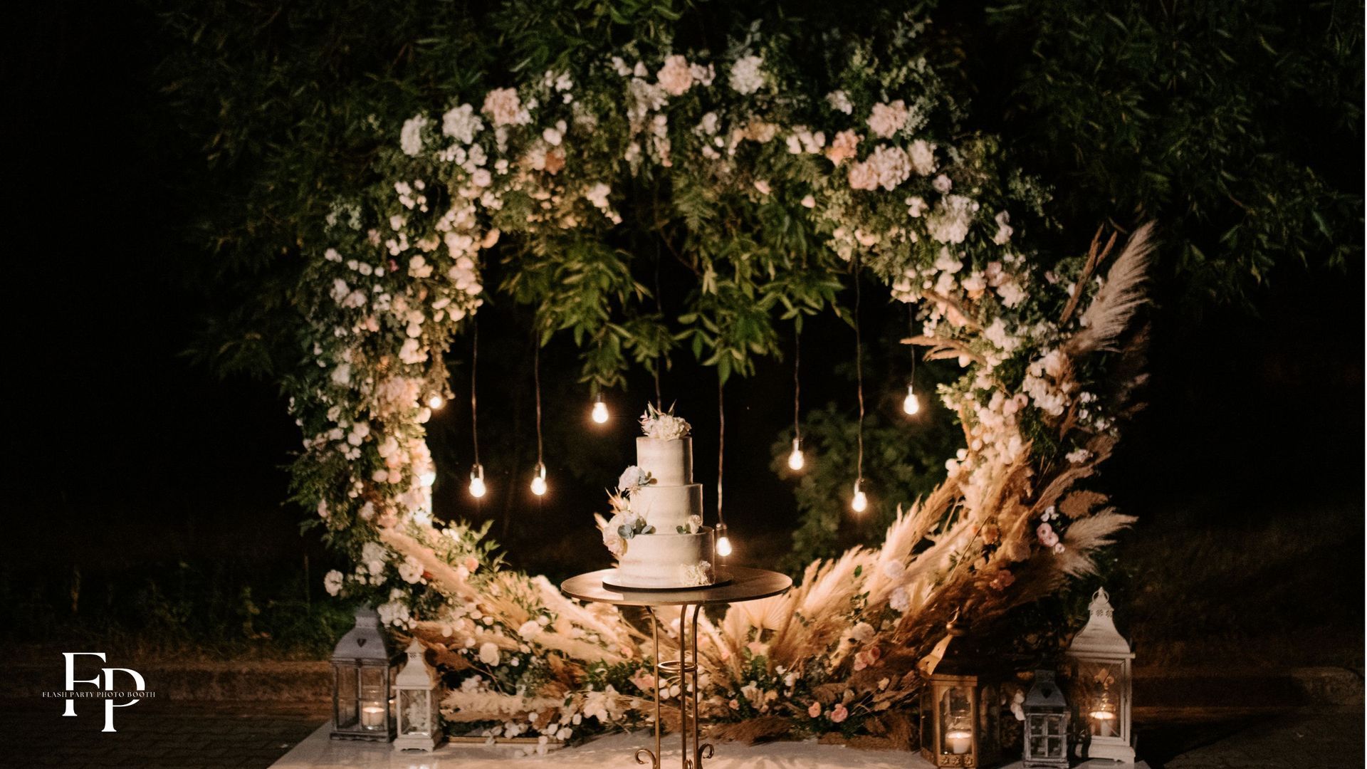 A wedding cake at the center of the wedding destination venue surrounded by a flower arrangement