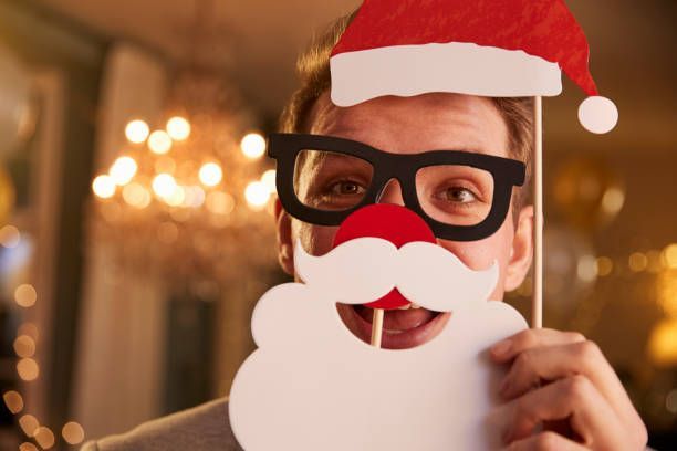 A man wearing a Santa hat and glasses props