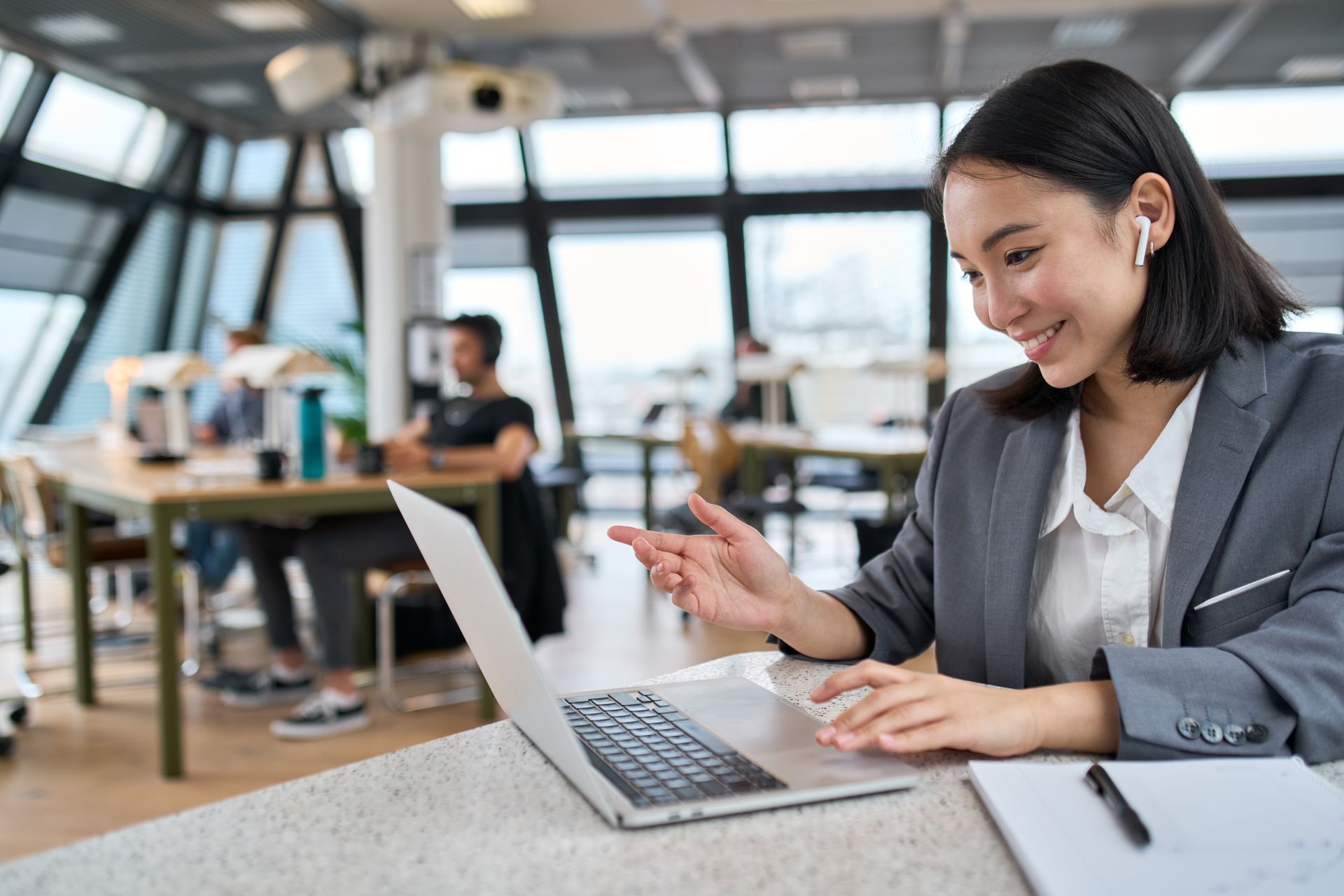 A woman is sitting at a table using a laptop computer.