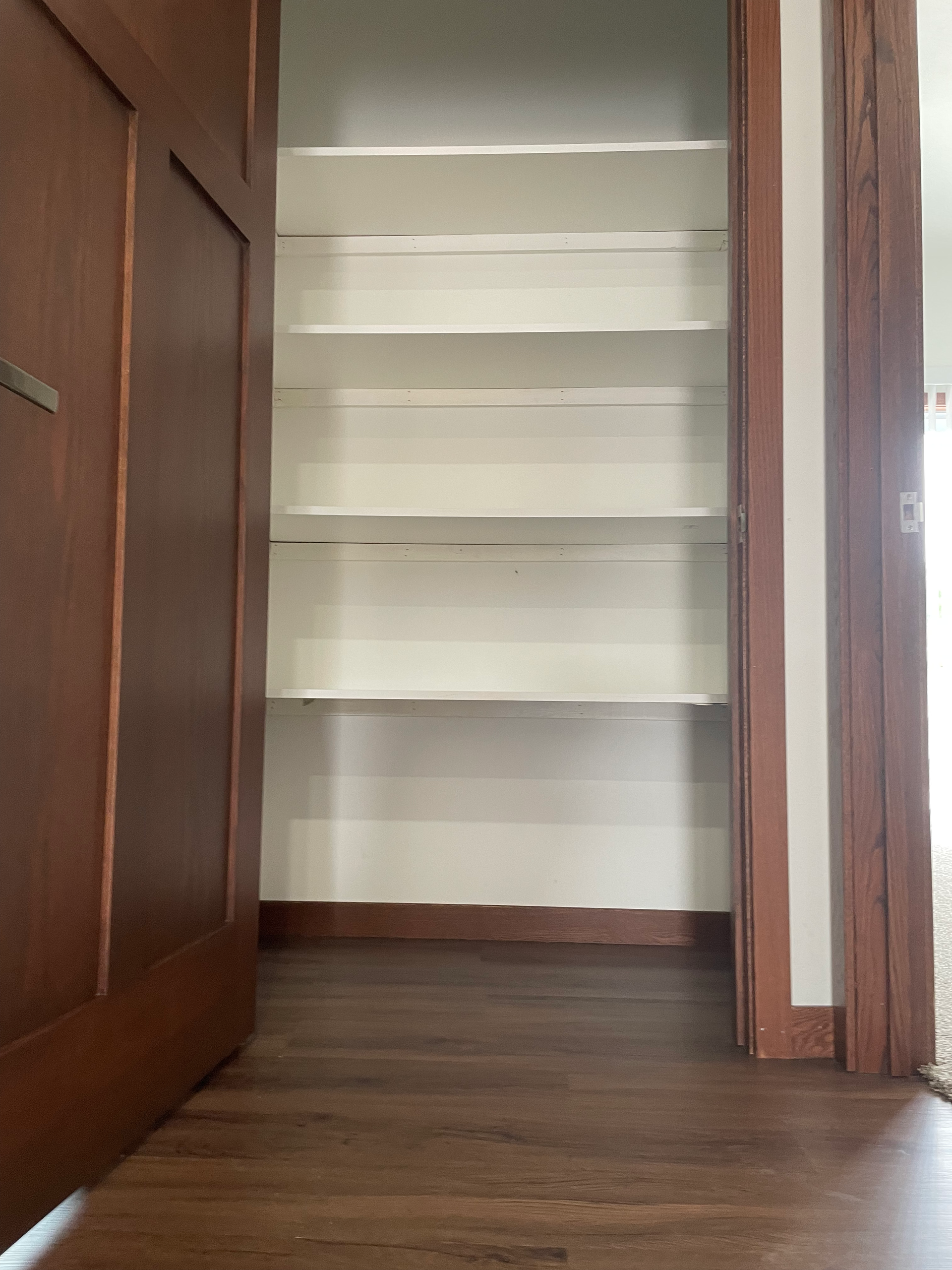 A closet with shelves and a wooden floor