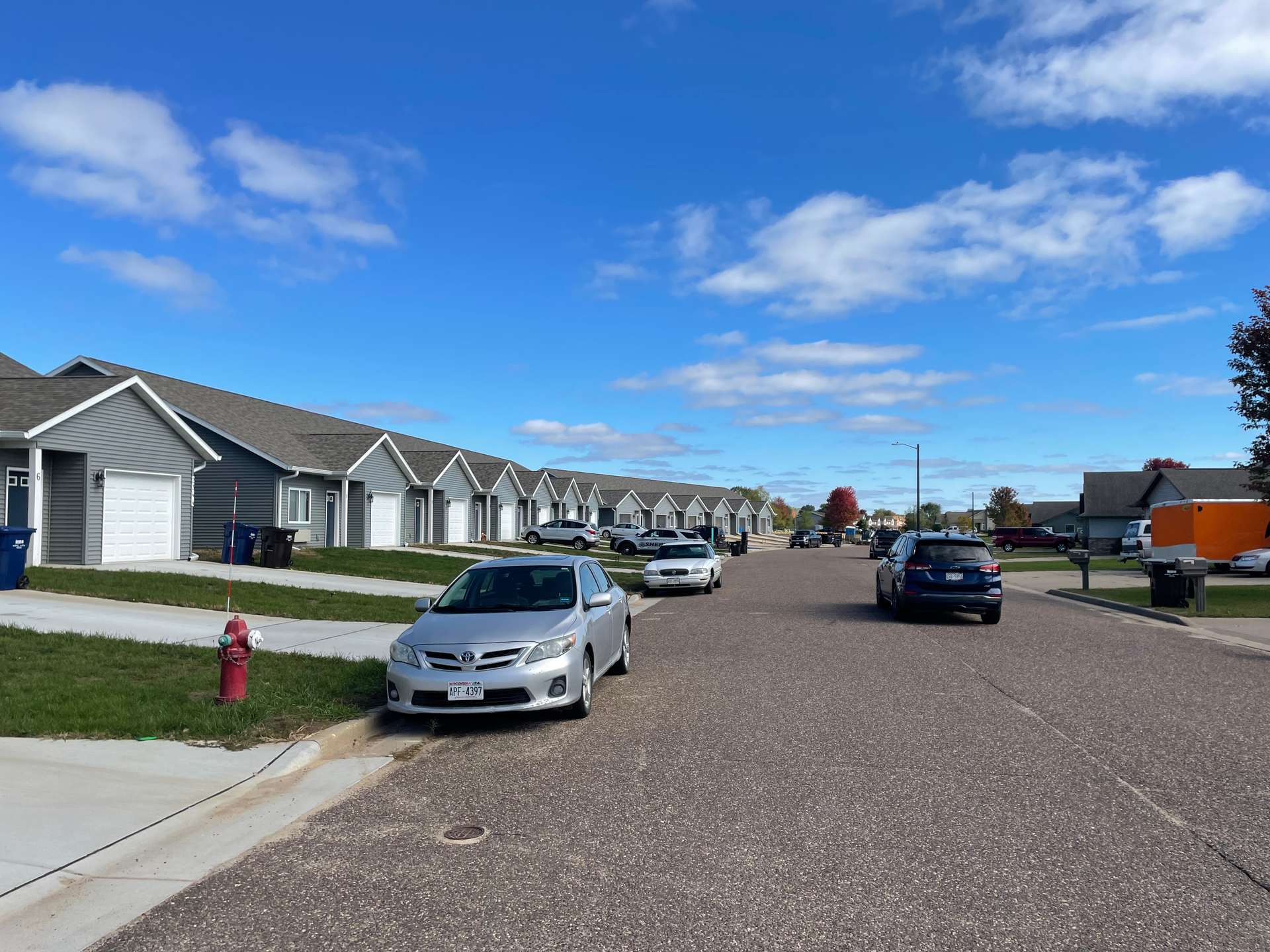 Cars are parked on the side of the road in a residential area