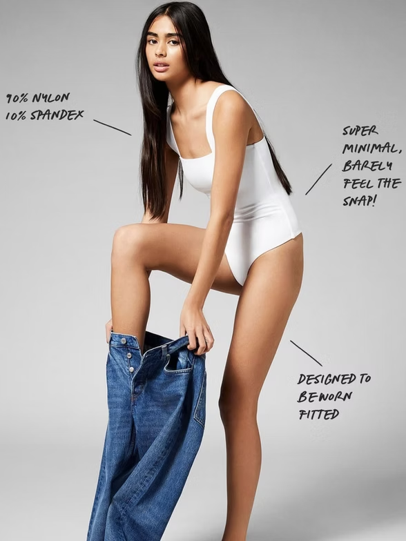 Woman in white bodysuit pulling on blue jeans, text overlay describes fabric and design.
