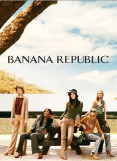Women in tan and olive-toned outfits pose outdoors on a bench, with the Banana Republic logo displayed.