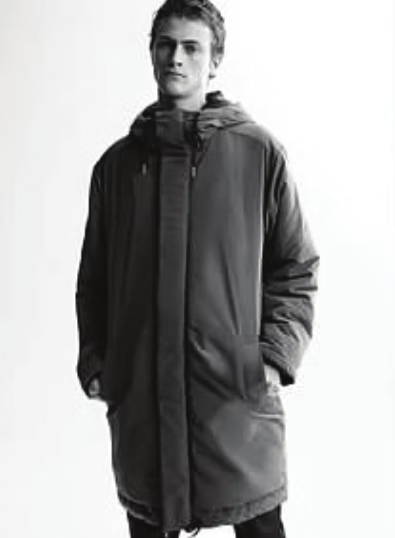 Man wearing a long, hooded puffer coat, hands in pockets.