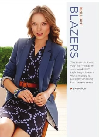 Woman wearing a blue blazer and patterned dress, sitting outside.