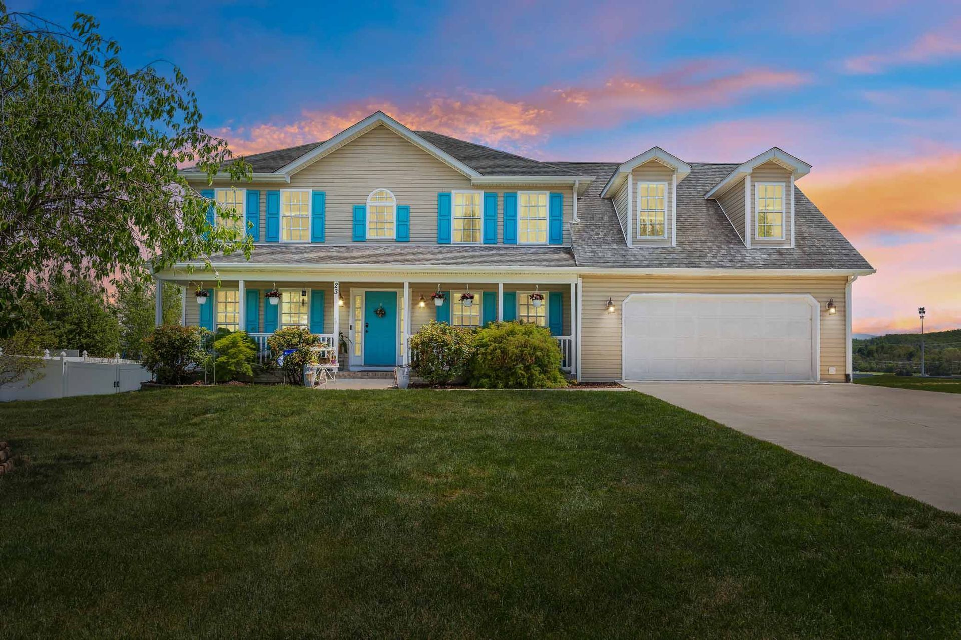 A large house with blue shutters and a large driveway.