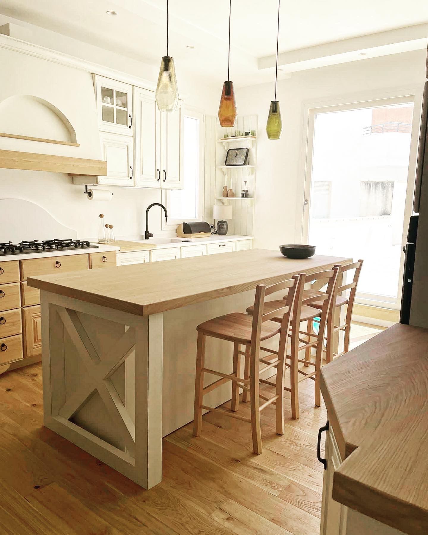 una cucina moderna con armadi bianchi e legno