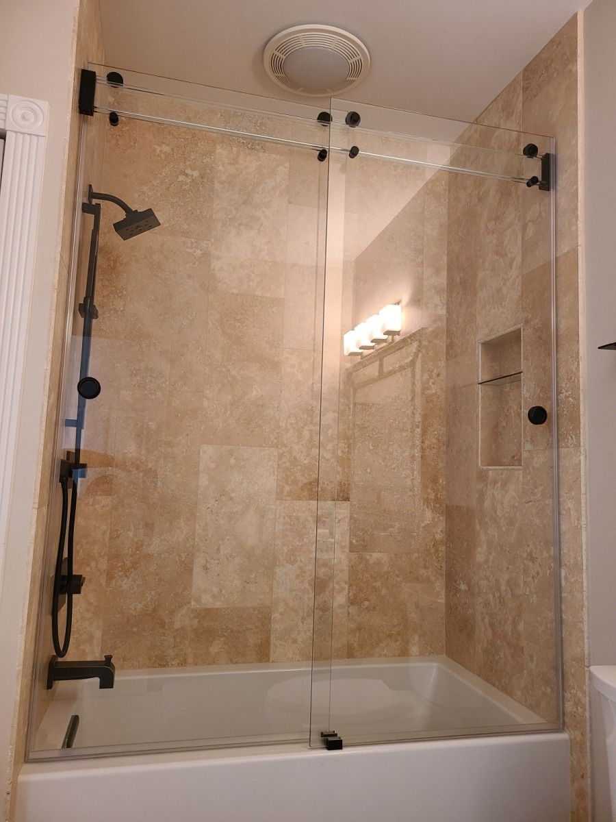 A bathroom with a tub and a shower with a sliding glass door.