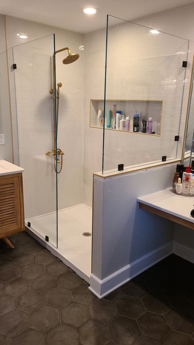 A bathroom with a walk in shower and a sink.