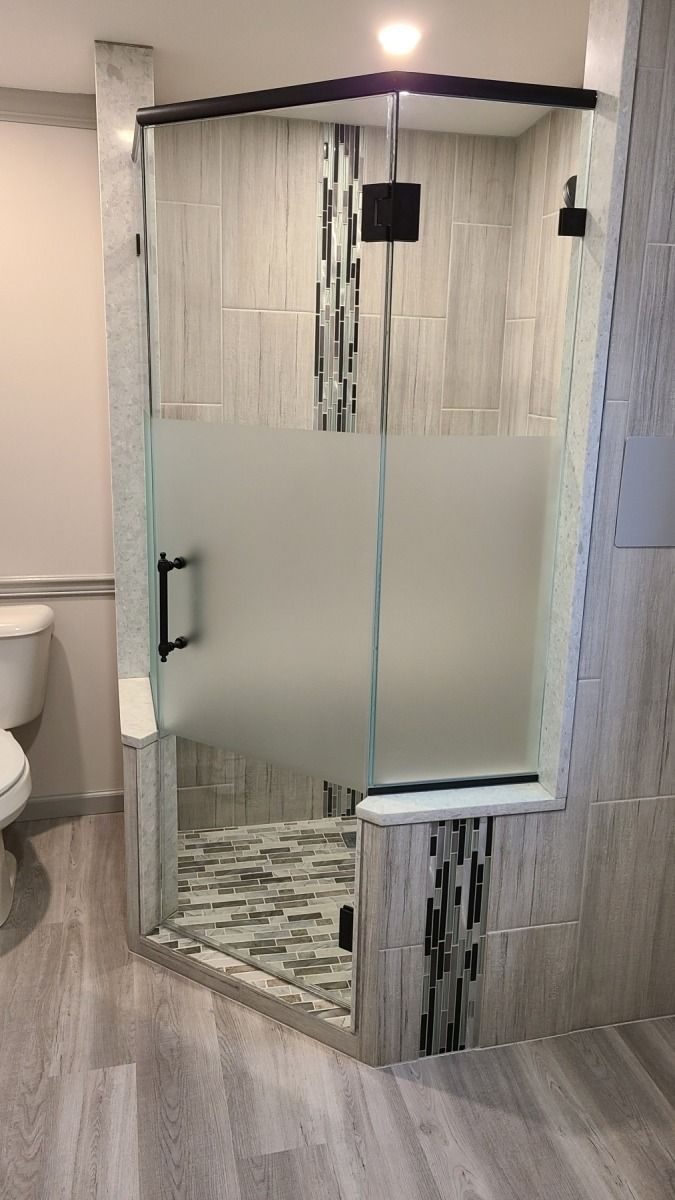 A bathroom with a walk in shower and a toilet.