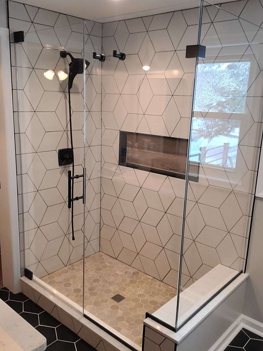 A bathroom with a walk in shower with a glass door
