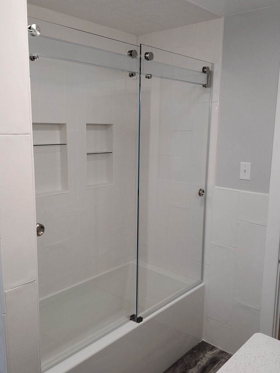 A bathroom with a bathtub and a sliding glass shower door.