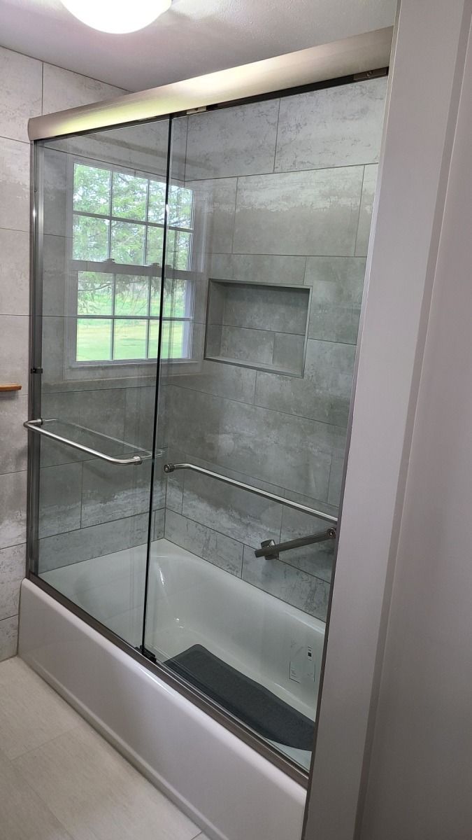 A bathroom with a bathtub and a sliding glass shower door.