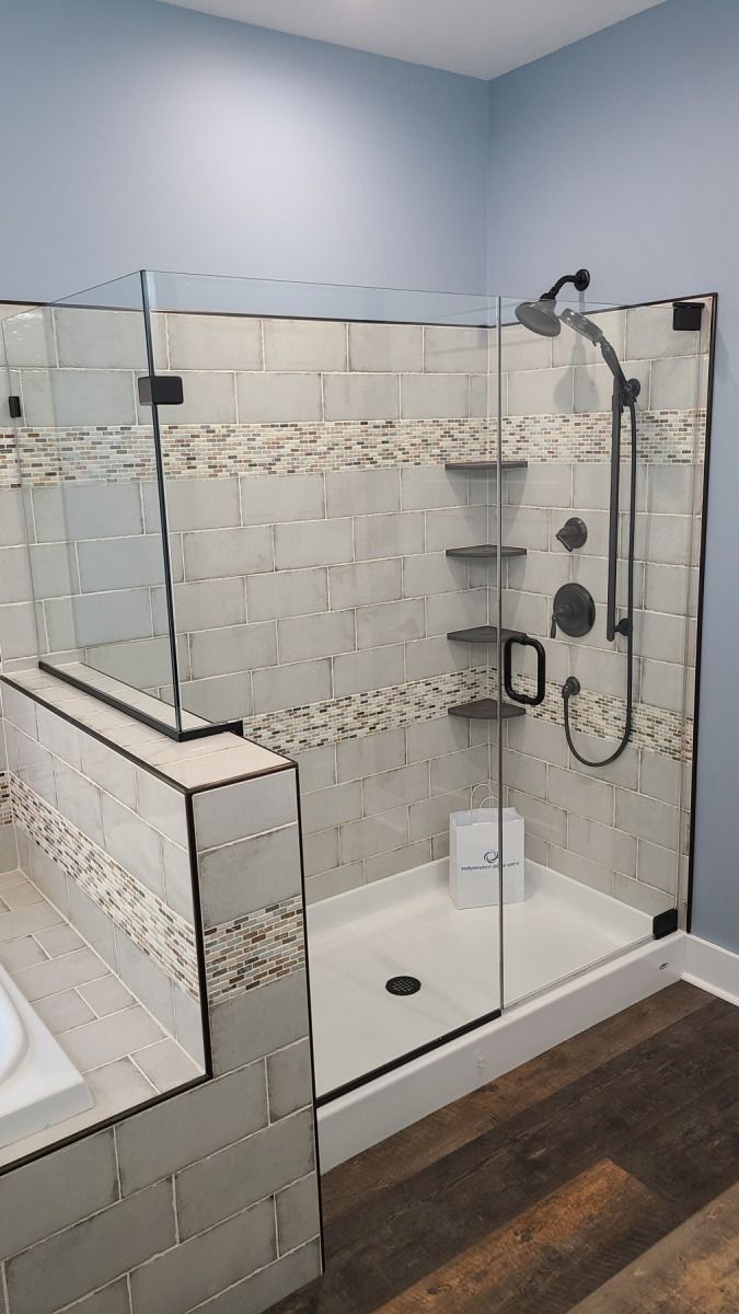 A bathroom with a walk in shower and a bathtub.