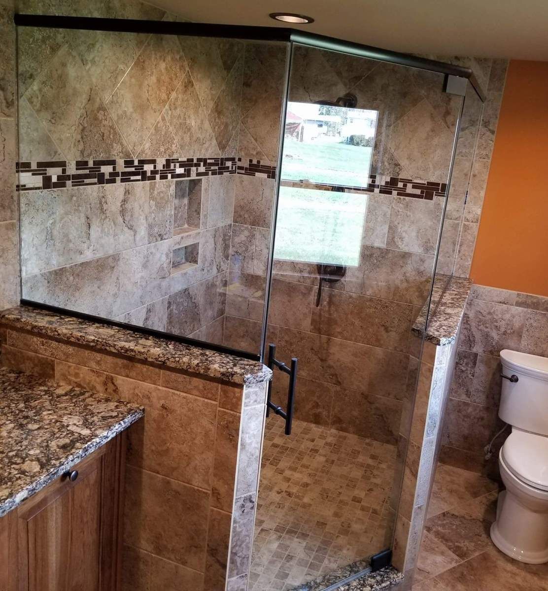 A bathroom with a walk in shower and a toilet.