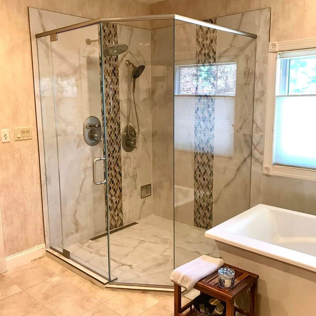 A bathroom with a walk in shower and a bathtub.