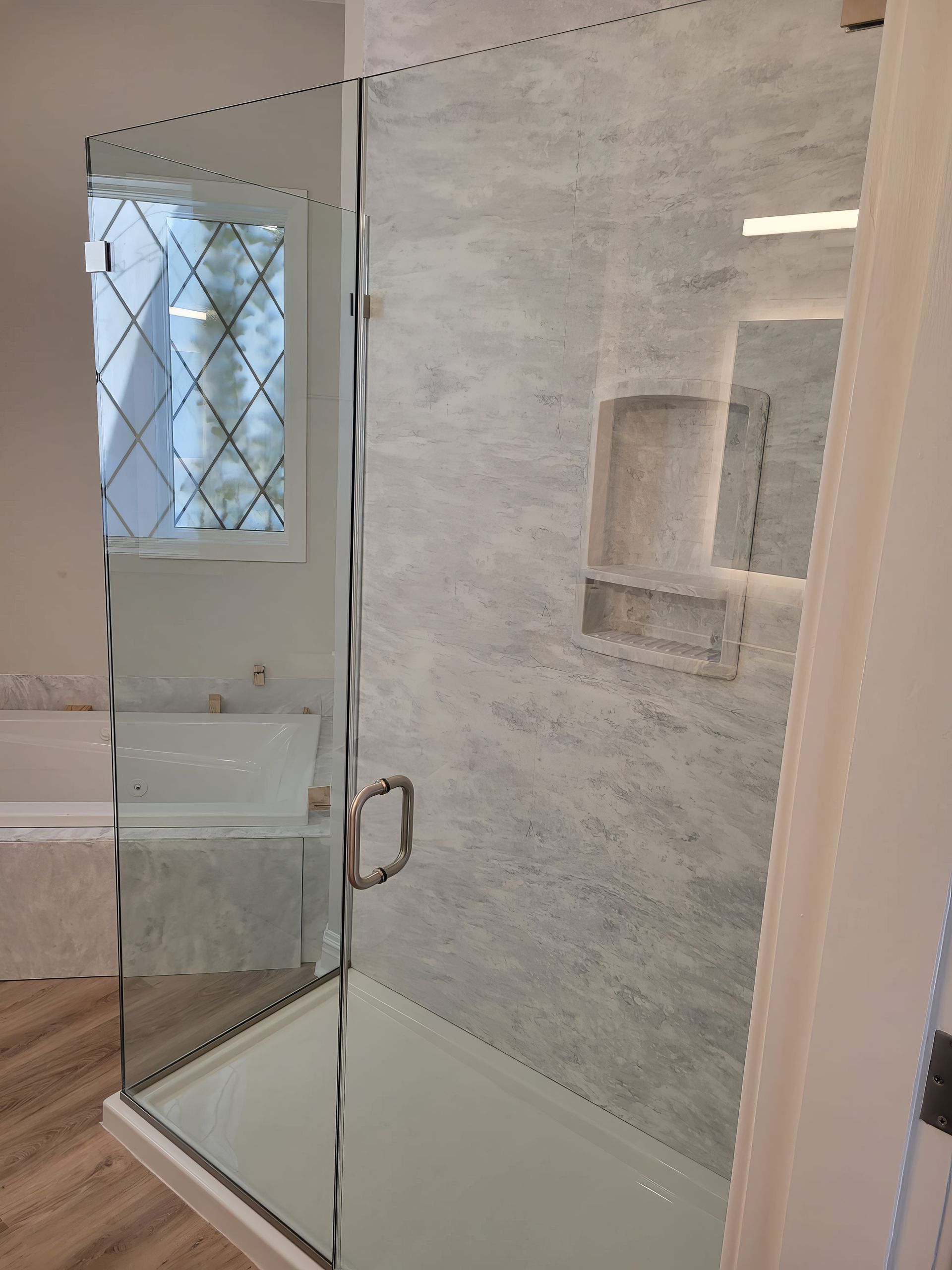 A bathroom with a walk in shower and a bathtub.