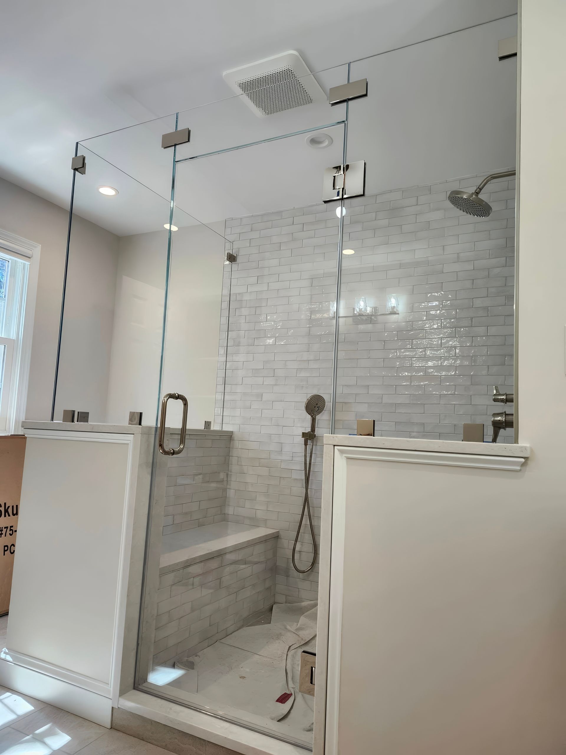 A bathroom with a walk in shower and a bench.