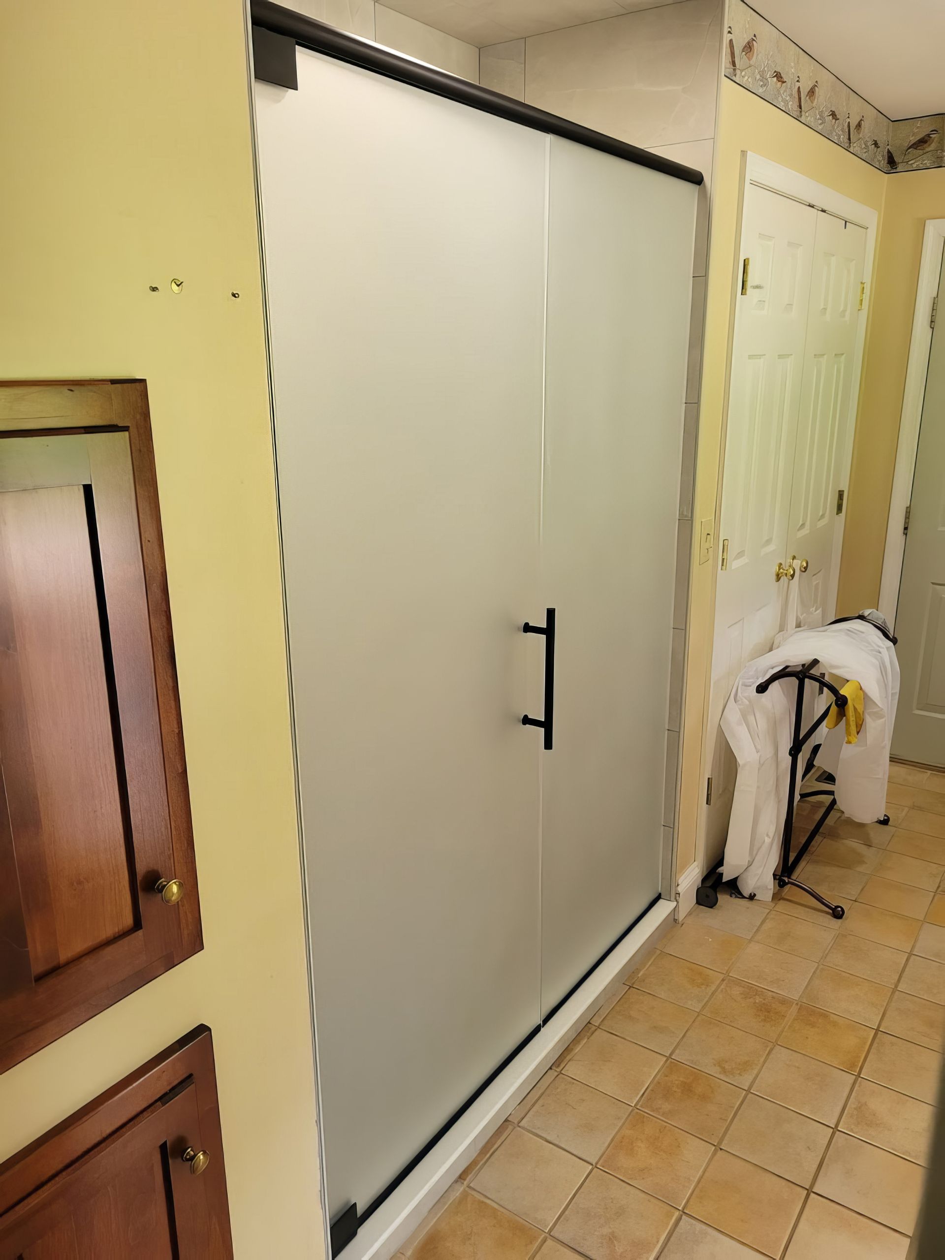 A bathroom with a sliding glass shower door