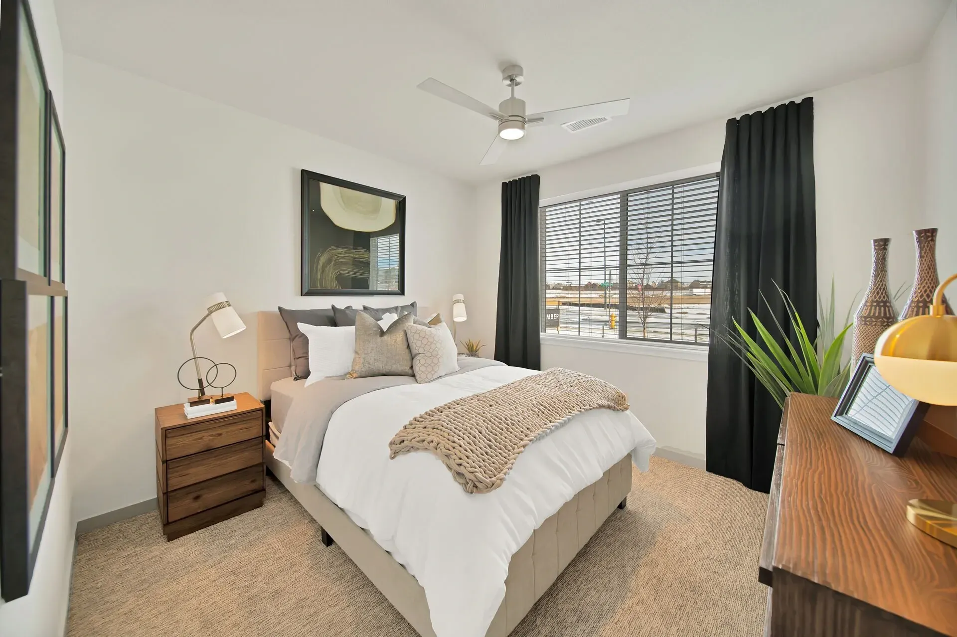 Cozy bedroom with a queen-size bed, ceiling fan, and large window.