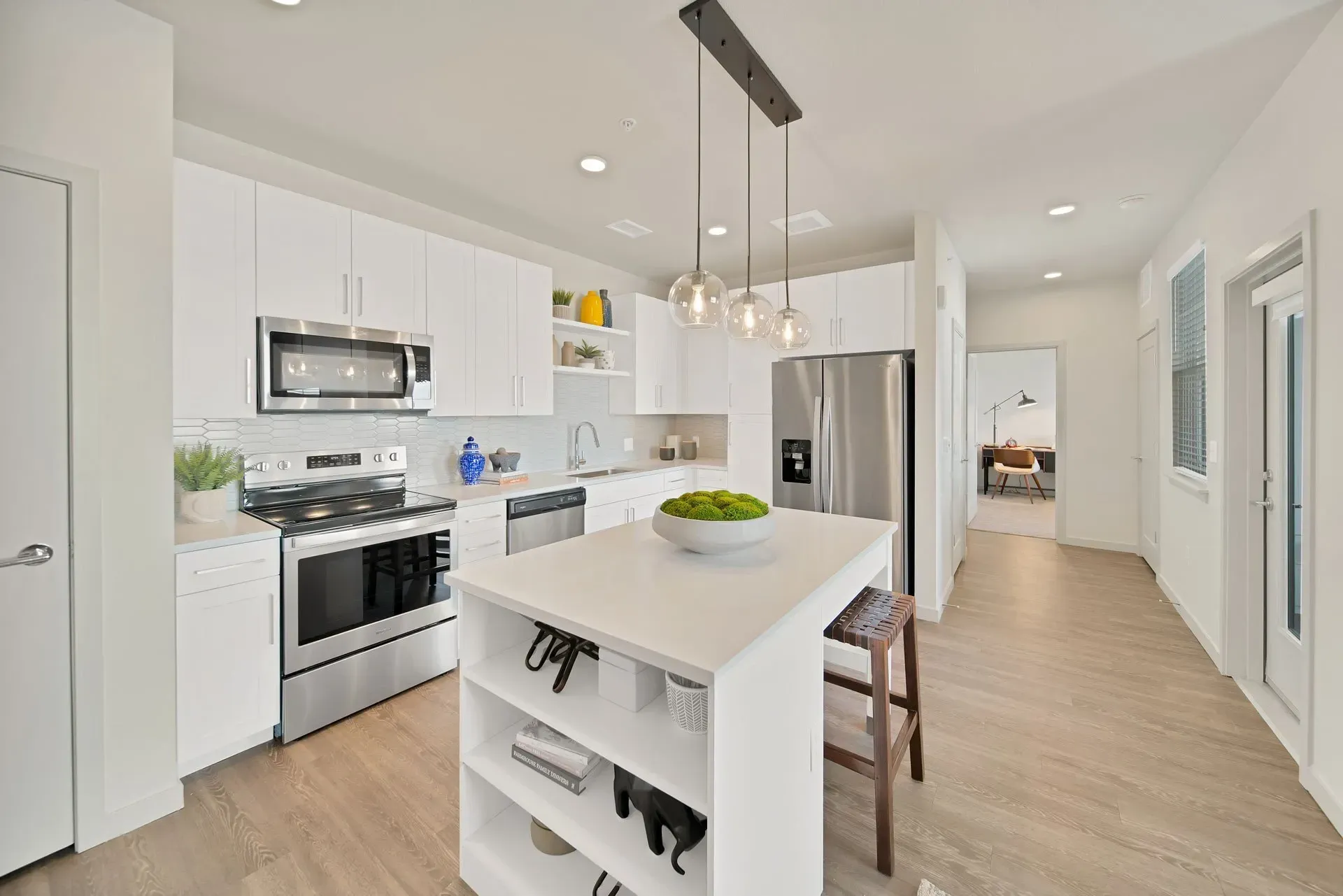 Modern kitchen with stainless steel appliances, white cabinets, and a center island.