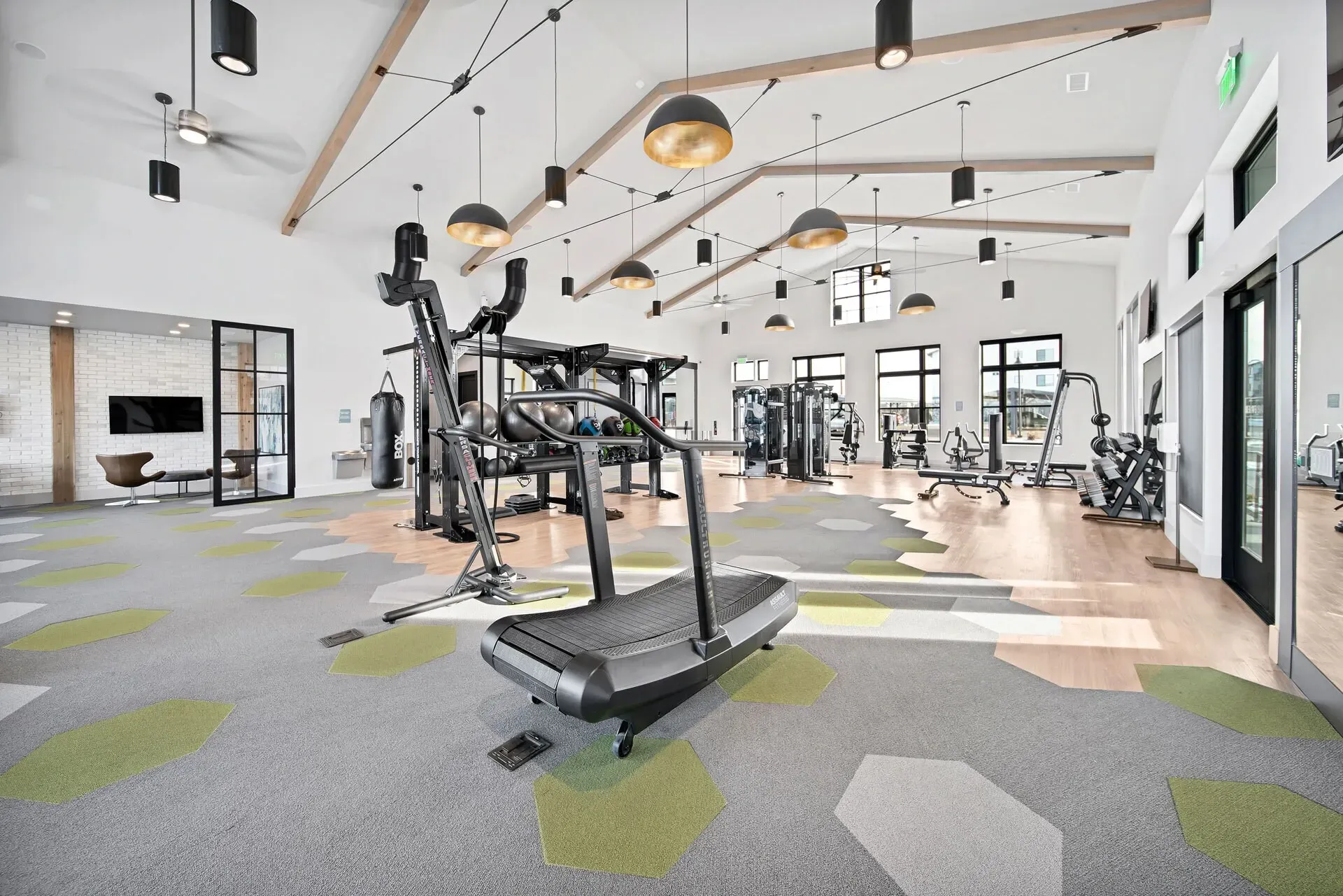 Interior of a modern apartment complex gym with cardio and weight machines.