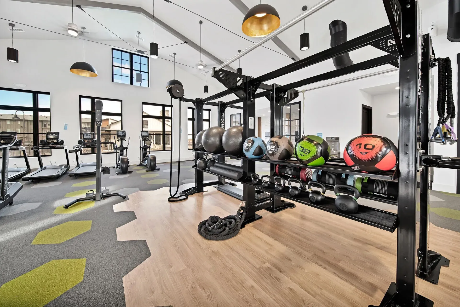 Treadmills, ellipticals, and weight training equipment in a modern gym.