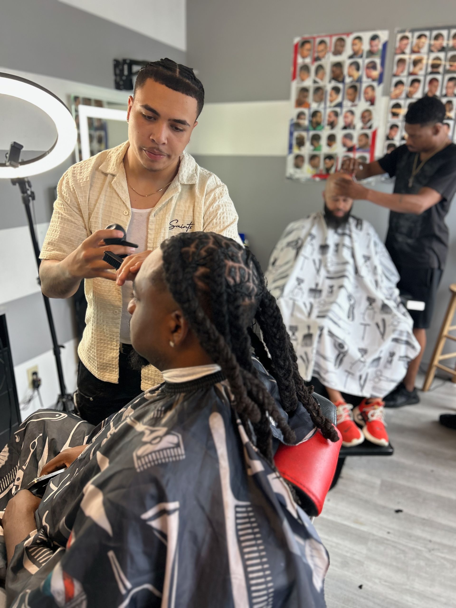 A group of men are getting their hair cut at a barber shop.