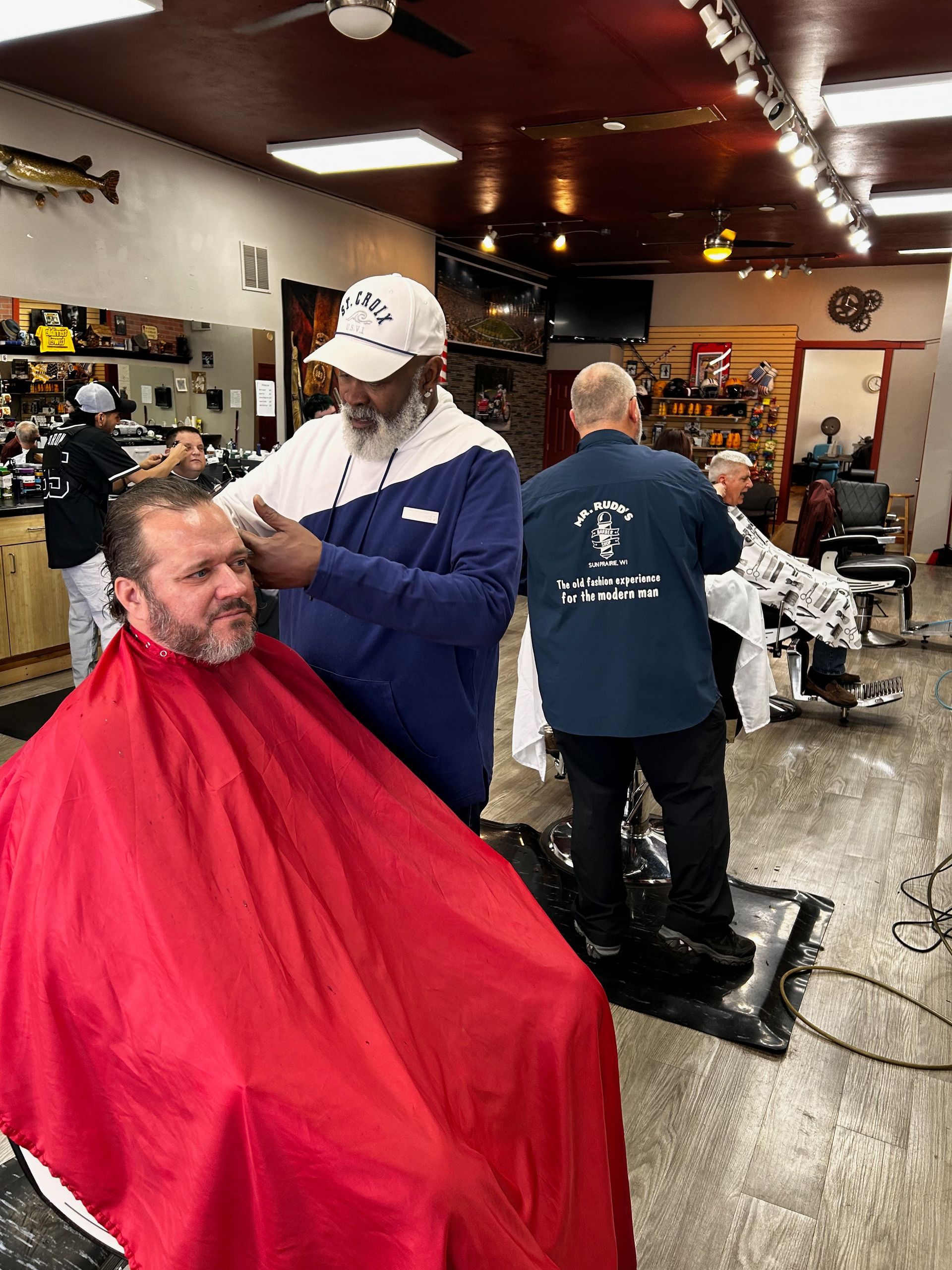 a man is getting his hair cut at a barber shop .