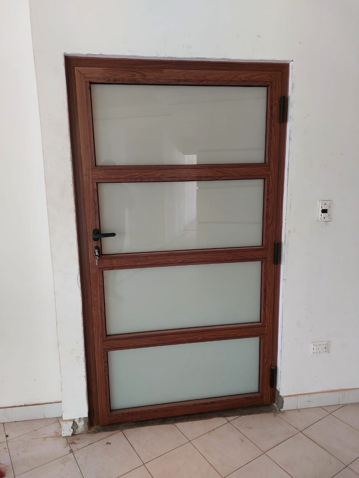 Una puerta de madera con vidrio esmerilado en una habitación.