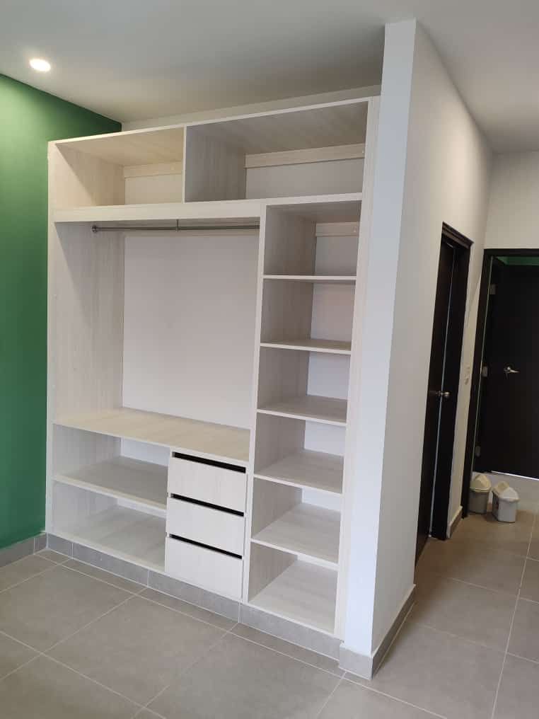 Un armario con muchos estantes y cajones en una habitación.