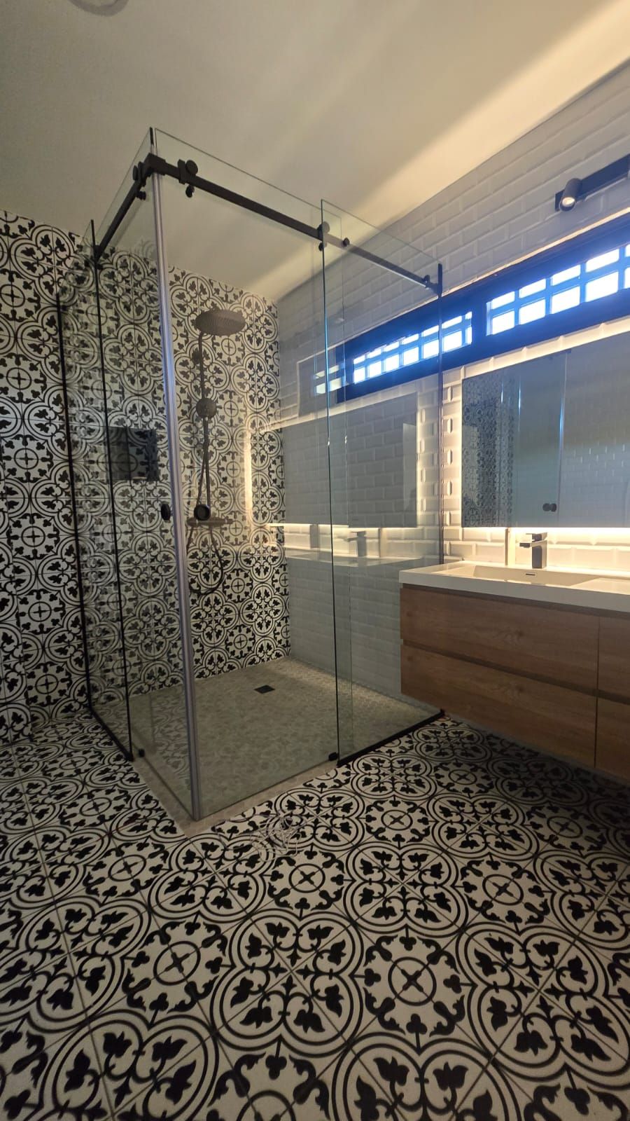 Un baño con ducha, lavabo y espejo.