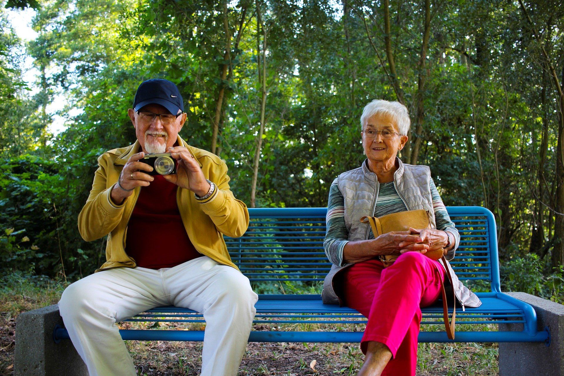 Elderly man and woman sitting on a bench enjoying the nice day.  Optimal Home Care is dedicated to helping clients achieve quality of life.