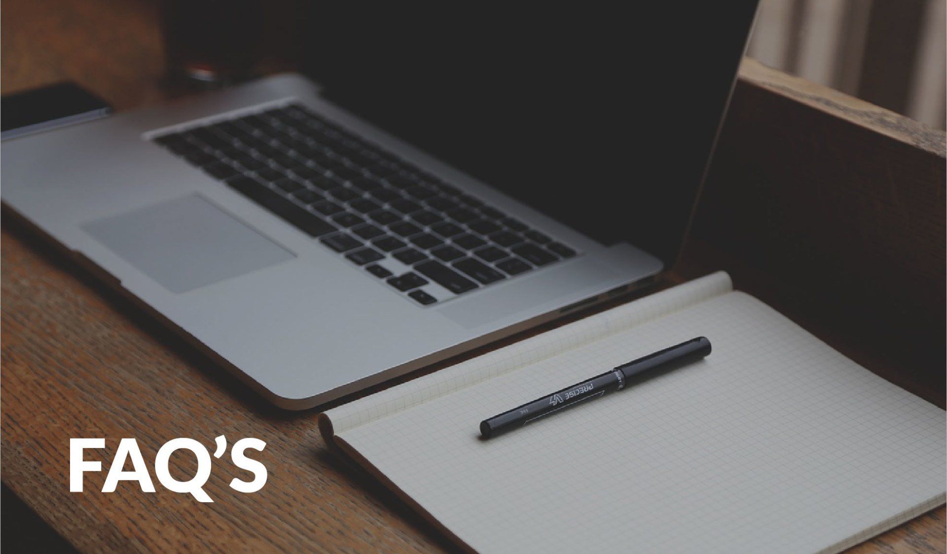 A laptop with a notebook and the text 