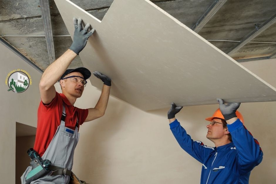 Two male installers secure a ceiling drywall panel in a Sherwood Park, AB home.