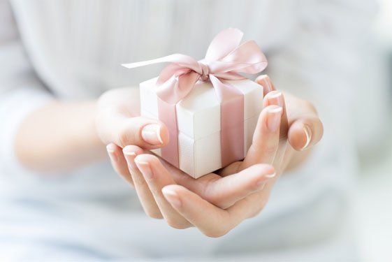 Woman handing out small gift - Gifts in Camden North Haven, NSW