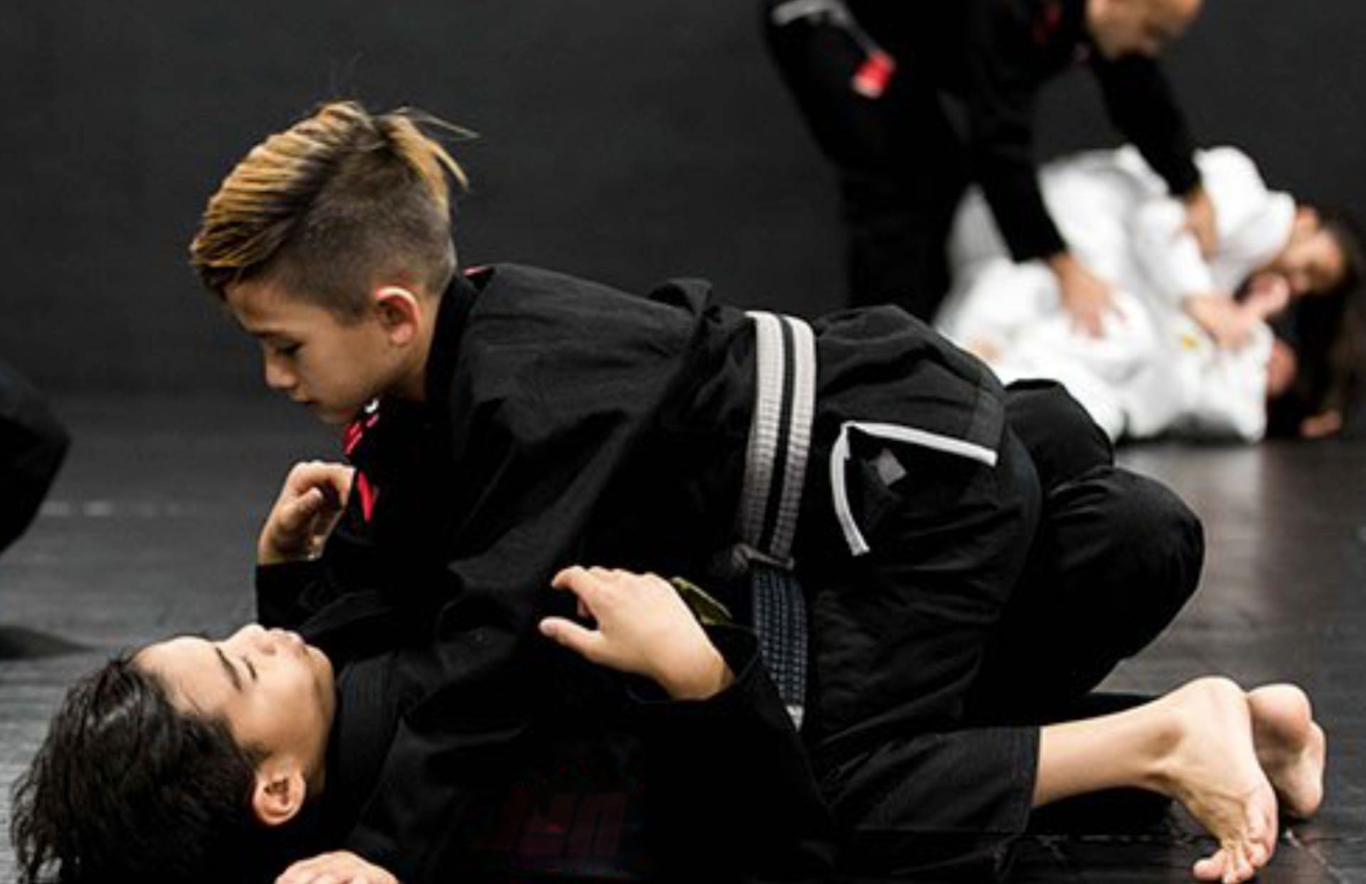 two students practicing BJJ from the side mount