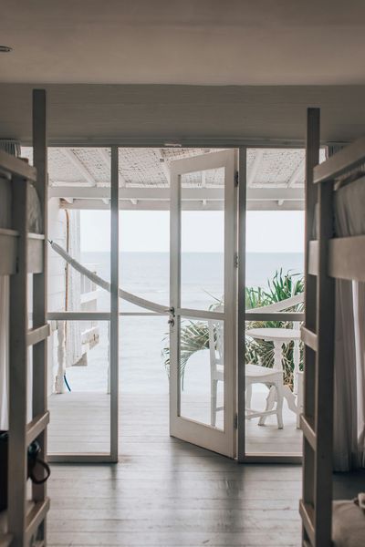 Bedroom doorway open to ocean view, flanked by white bunk beds.