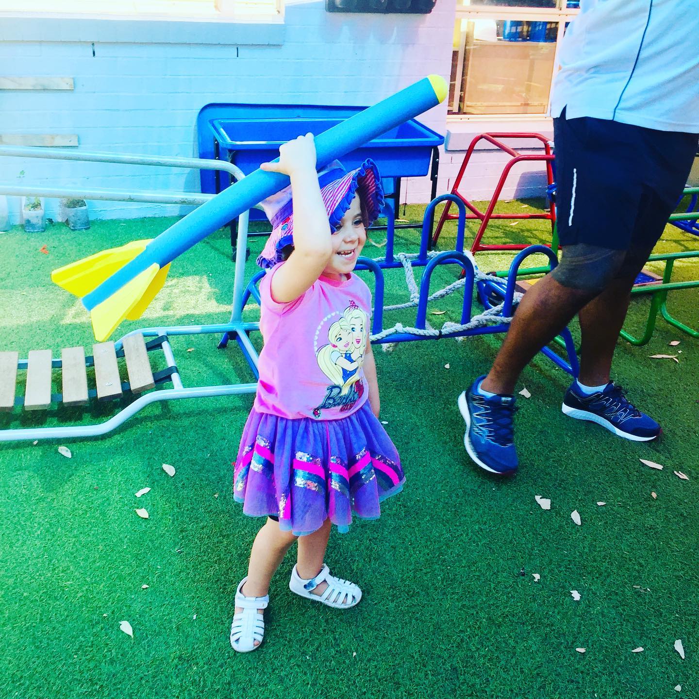 a girl holding a big toy dart