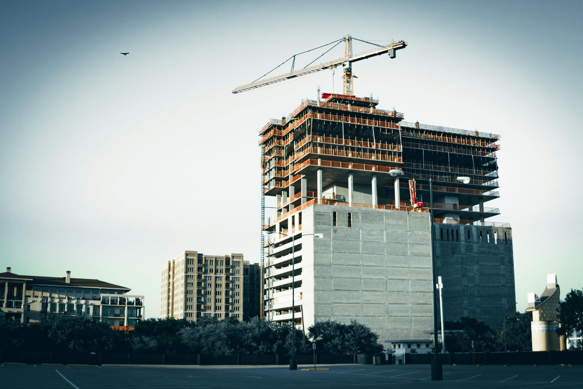 Construction crane over a partially built high-rise building in an urban area